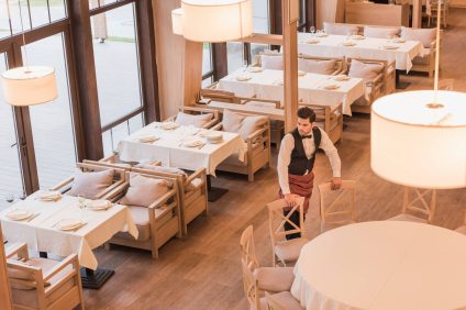 waiter-putting-chairs-around-table-in-a-restaurant-2024-11-18-22-50-48-utc (1)